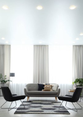 Rahat kanepe ve koltukları olan modern oturma odası.