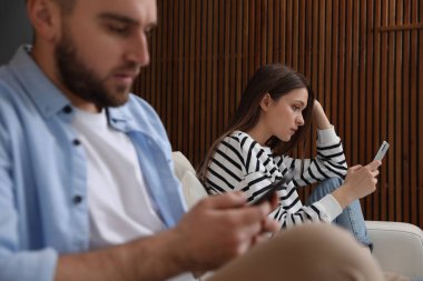 Evde birbirini görmezden gelen akıllı telefonlara bağımlı bir çift. İlişki sorunları