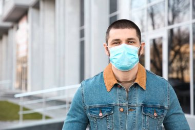 Açık havada tek kullanımlık maske takan bir adam. Tehlikeli bir virüs.