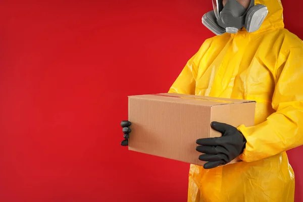Homem Terno Proteção Química Segurando Caixa Papelão Fundo Vermelho Vista — Fotografia de Stock