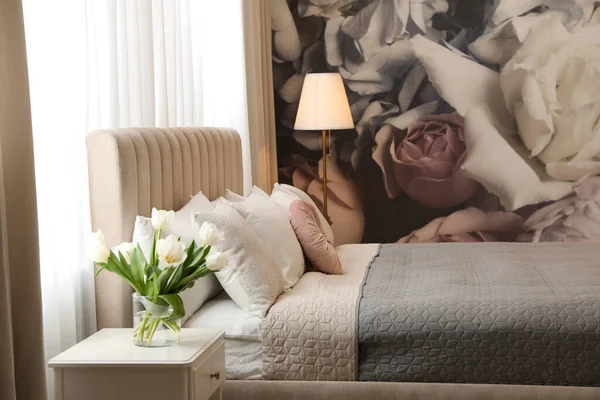 壁に大きな快適なベッドと花のパターンと美しい部屋のインテリア — ストック写真