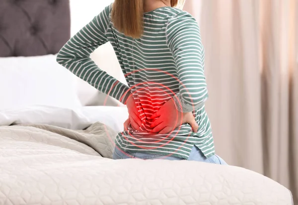 自宅で不快なマットレスの上で寝て背中の痛みに苦しんでいる女性 クローズアップ — ストック写真