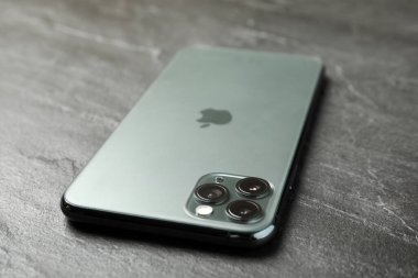MYKOLAIV, UKRAINE - 12 Mart 2020: iPhone 11 Gri taş fon üzerine Pro Midnight Green