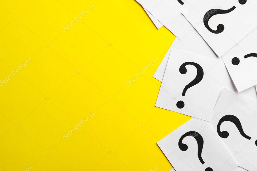 Paper notes with question marks on yellow background, flat lay. Space for text