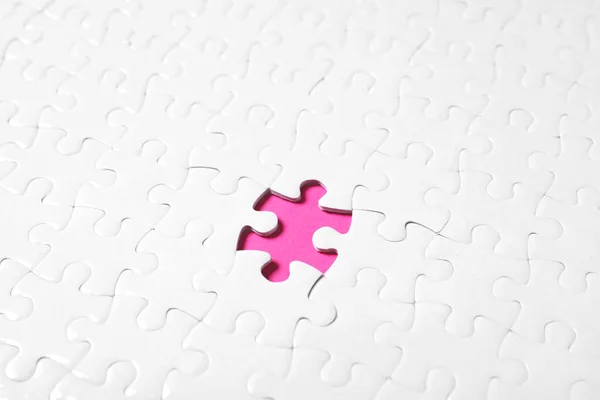 空白の白いパズルともに欠片上のピンクの背景 — ストック写真