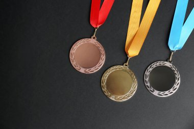Siyah arka planda altın, gümüş ve bronz madalyalar, düz yatış. Tasarım için boşluk