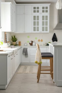 Modern mutfak içi şık beyaz mobilyalarla dolu.