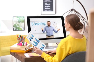 Evde online çalışmak için dizüstü bilgisayar kullanan genç bir kadın