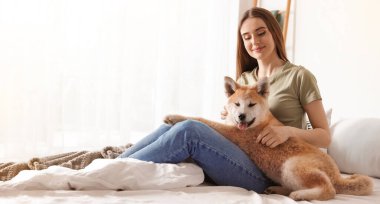 Evinde şirin Akita Inu köpeği olan genç bir kadın, afiş tasarımı. Sevimli hayvan