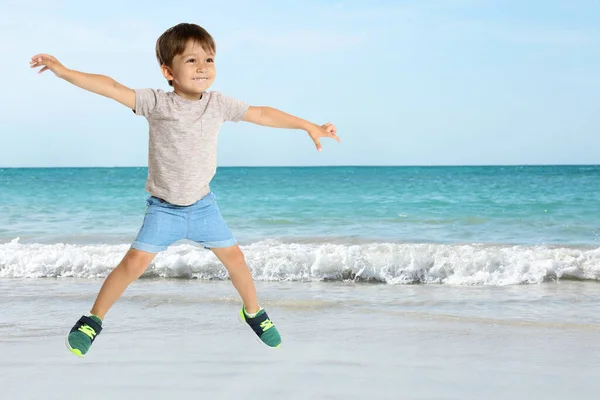 Menino Escola Feliz Pulando Praia Perto Mar Espaço Para Texto — Fotografia de Stock