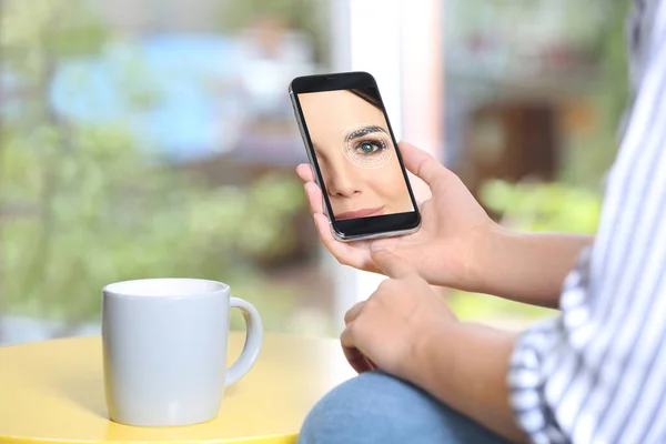 Kvinna Med Hjälp Smartphone Med Ansiktsigenkänningssystem Vid Bordet Inomhus Närbild — Stockfoto