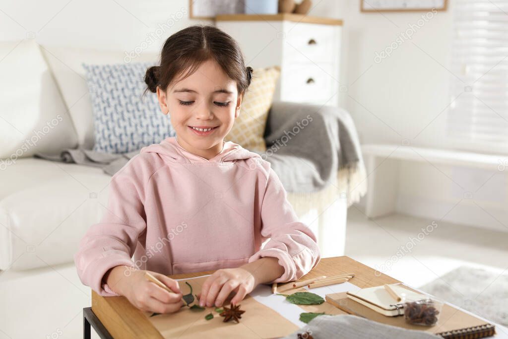 Little girl working with natural materials at table indoors. Creative hobby