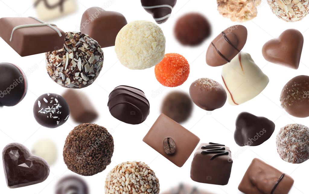 Different chocolate candies falling on white background