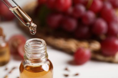 Doğal üzüm tohumu yağını şişeye damlatarak, yazı için yere yakın çekim yaparak. Organik kozmetik