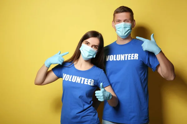 Voluntarios Máscaras Guantes Sobre Fondo Amarillo Medidas Protección Durante Cuarentena — Foto de Stock