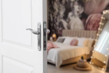 Modern otel odasına açılan beyaz kapı, yakın plan.