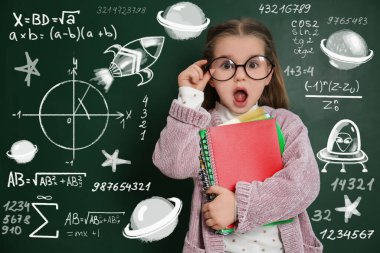 Cute little child in glasses near chalkboard with constitutive equations. First time at school clipart