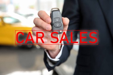 Araba galerisinde anahtarı olan satıcı, yakın plan.