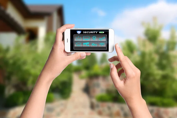 Frau Überwacht Moderne Cctv Kameras Smartphone Der Nähe Ihres Hauses — Stockfoto