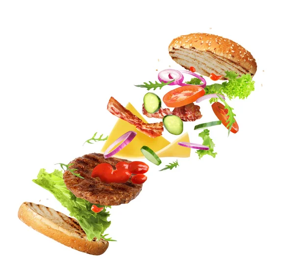 Delicious burger with different flying ingredients on white background