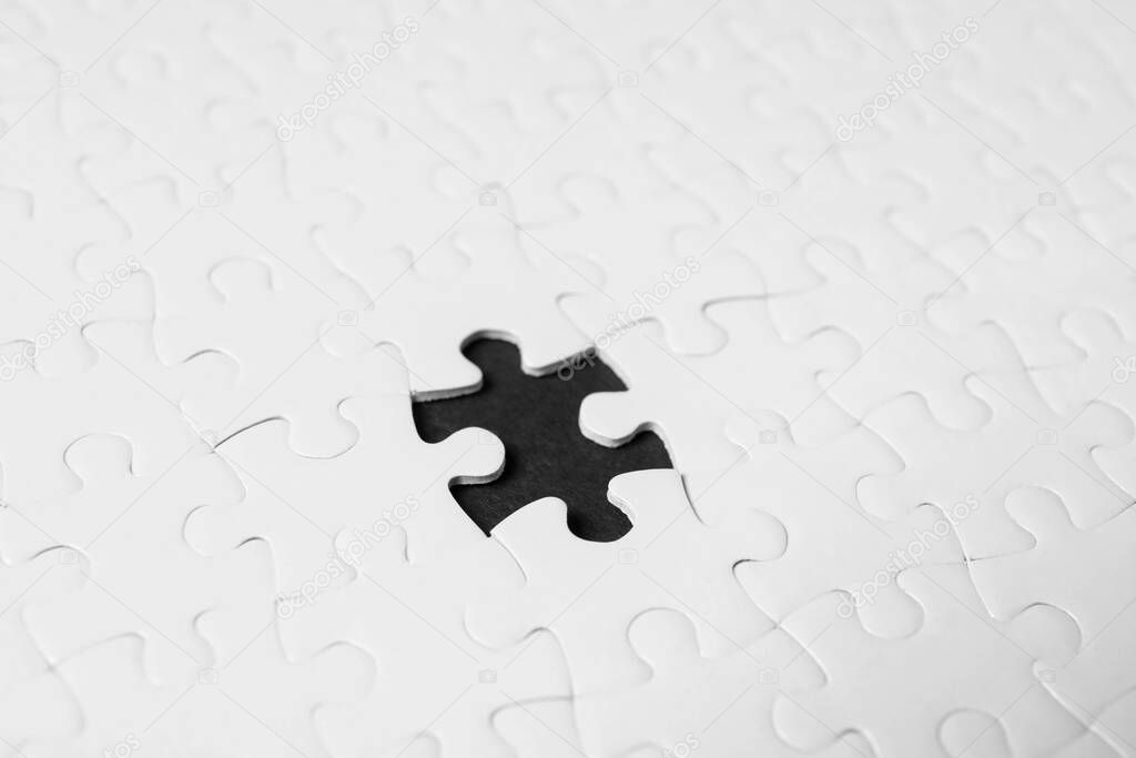 Blank white puzzle with missing piece on black background