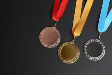 Siyah arka planda altın, gümüş ve bronz madalyalar, düz yatış. Tasarım için boşluk