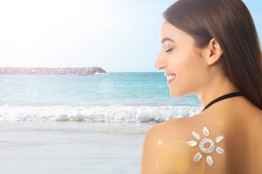 Plajda sırtında güneş kremi olan bir kadın, mesaj atmak için yer var.