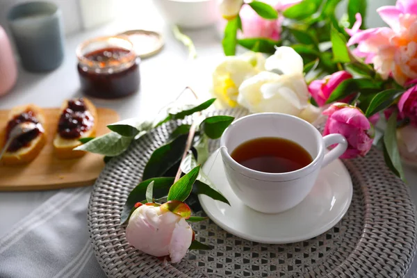 漂亮的牡丹和一杯茶放在桌上 — 图库照片