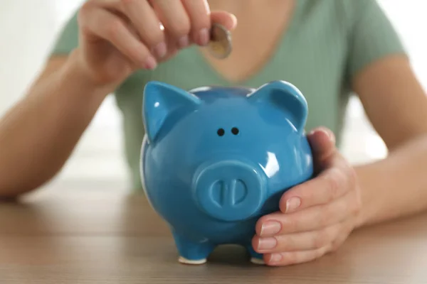 Mujer Poniendo Dinero Alcancía Mesa Madera Interior Primer Plano — Foto de Stock