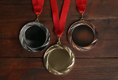 Tahta arka planda altın, gümüş ve bronz madalyalar, düz yatış. Tasarım için boşluk