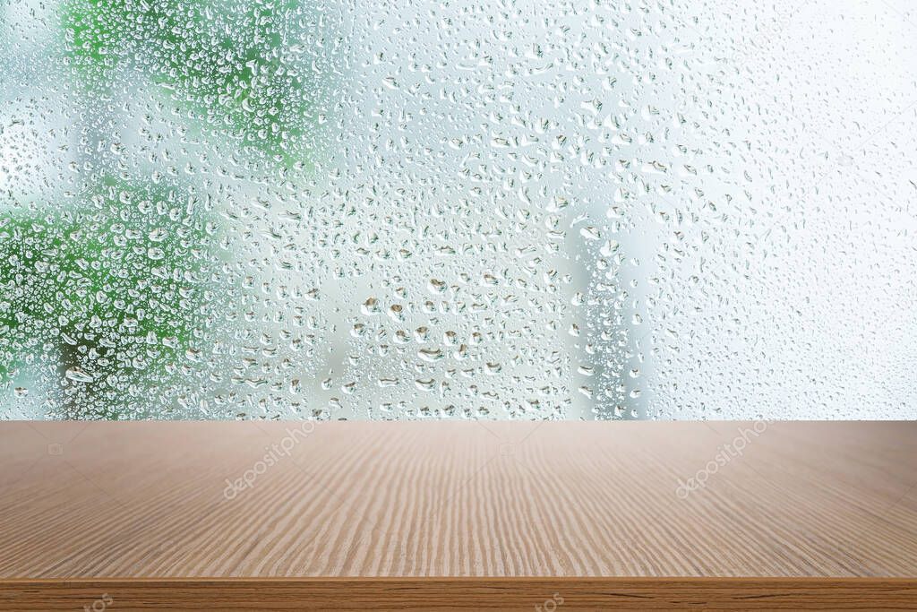 Wooden table near window on rainy day