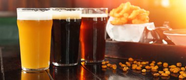 Bardaki ahşap masada lezzetli bira ve atıştırmalıklar. Pankart tasarımı