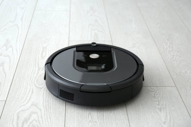 Ahşap zeminde modern robot süpürge.
