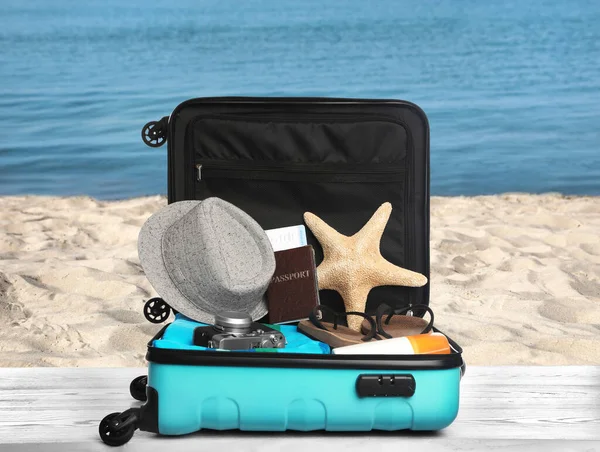 Suitcase Different Beach Objects Grey Wooden Table Sea — Stock Photo, Image