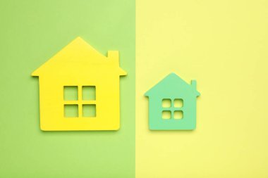 Renkli arka planda küçük ve büyük ev figürleri, düz yatış. Pareto ilke kavramı