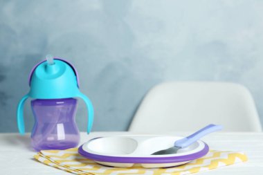 Plastik bulaşık takımı beyaz masaya. Bebek maması servisi.