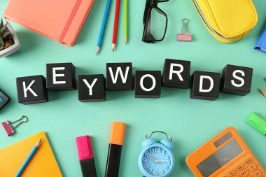 Yeşil arkaplanda siyah küplerden yapılmış KEYWORDS metni ile düz konum