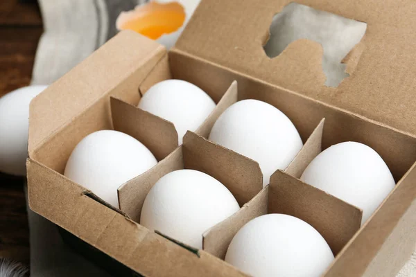 Fresh raw chicken eggs in box on table, closeup
