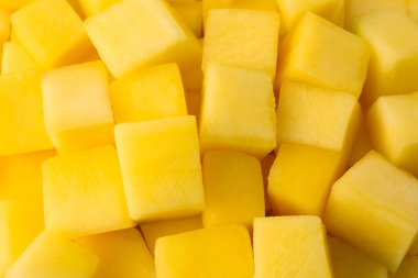 Arka plan olarak pek çok lezzetli mango küpü, yakın plan