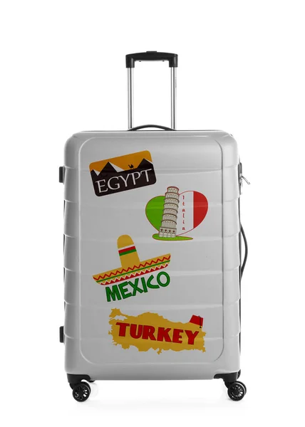 Modern suitcase with travel stickers on white background