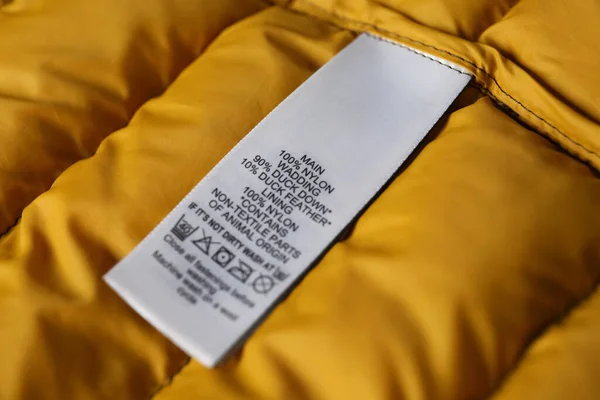 Etiqueta Ropa Con Símbolos Cuidado Contenido Material Chaqueta Amarilla Vista — Foto de Stock