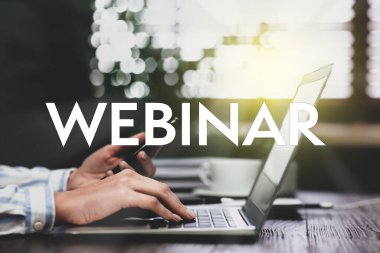 Akıllı telefonlu bir kadın masadaki modern dizüstü bilgisayarda çalışıyor, yakın plan. İş webinar