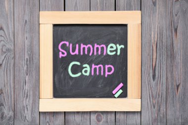 Tahta, tahta zemin üzerinde YAZ CAMP yazılı yazı tahtası, üst görünüm