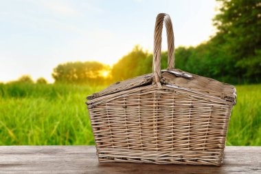 Piknik sepeti parktaki ahşap masada.