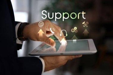 Dijital tablet kullanan iş adamı ve bulanık arkaplanda farklı simgeler, yakın plan. Teknik Destek Servisi 