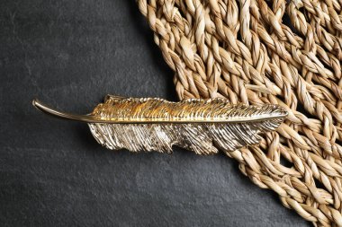 Güzel altın saç tokası ve hasır hasırla siyah masa, üst manzara