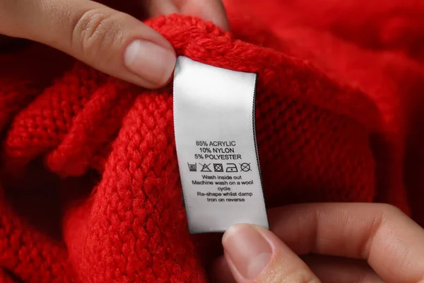 Mujer Leyendo Etiqueta Ropa Con Símbolos Cuidado Contenido Material Suéter — Foto de Stock