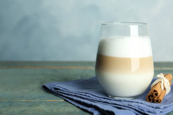 Köstlicher Latte Macchiato Und Zimt Auf Holztisch Vor Hellblauem Hintergrund — Stockfoto
