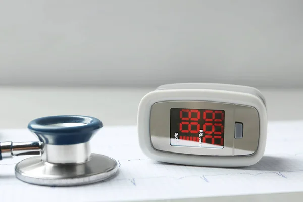 Modern Fingertip Pulse Oximeter Stethoscope Cardiogram Grey Table Closeup — Stock Photo, Image