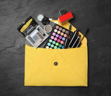 Siyah arkaplanda makyaj ürünleri olan kozmetik çanta.